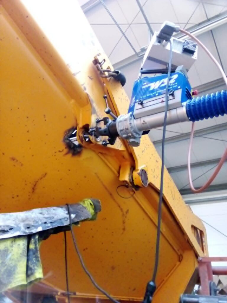 Mobilna regeneracja i wytaczanie otworów w ramie czerwonej maszyny rolniczej.